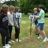 Diego und Jonas schlagen hier auf der Wiese in der Grünanlage Plantage den ersten Hummel-Pin in den Boden, beobachtet von Romy, Nicola und Mia (von links).