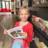 Die 6-Jährige Emilia schaut sich in der Tourist Information den Ferienkalender der Stadt Halberstadt an.