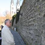 Halberstadts Oberbürgermeister Andreas Henke (links) und Gäste der Veranstaltung lesen den Text auf der Gedenktafel, die zu Ehren und in Erinnerung an das Leben der jüdischen Familie Winter im Haus Düsterngraben 26 an der Dombergmauer enthüllt worden